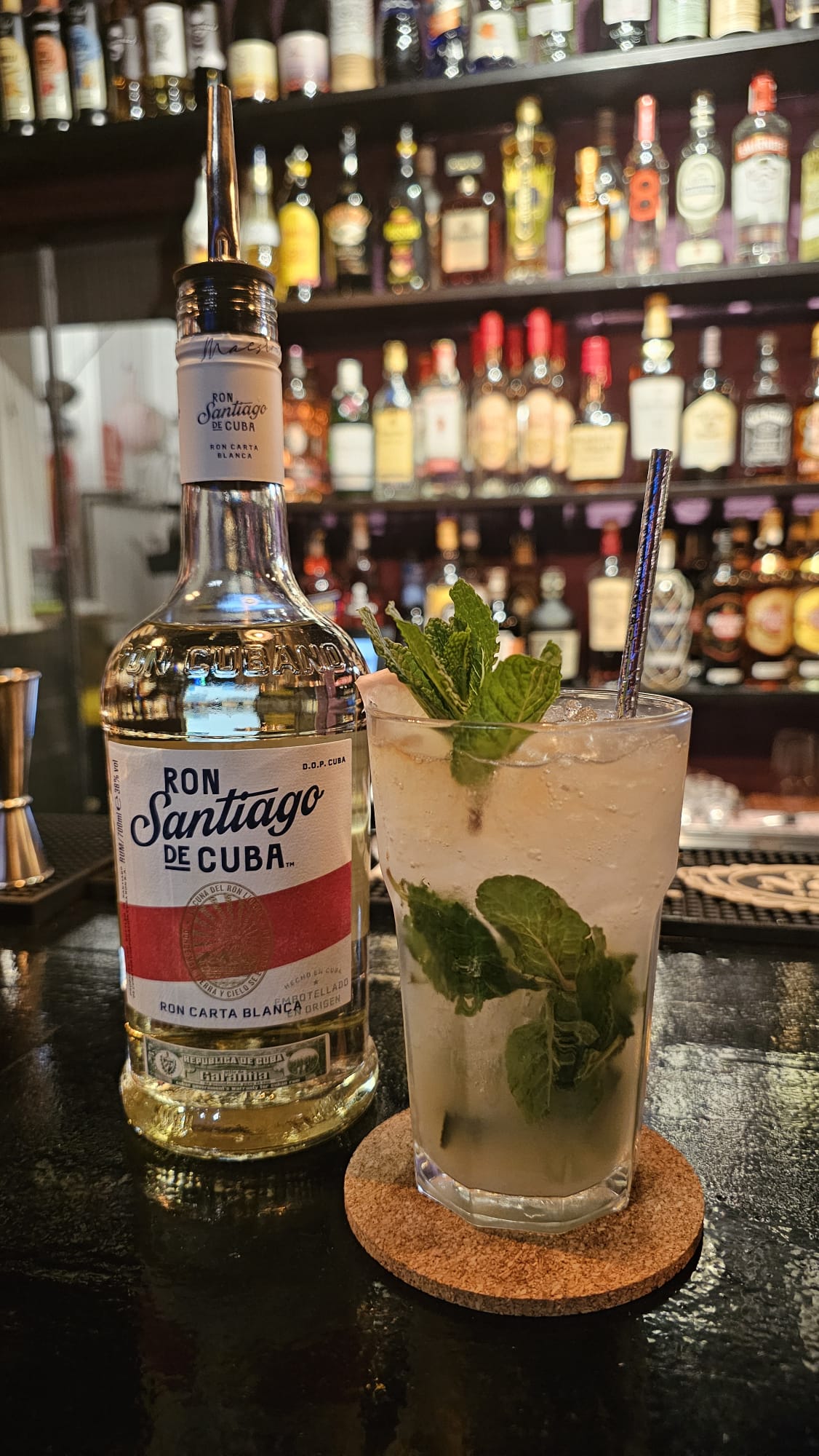 Mojito y botella de ron en la barra